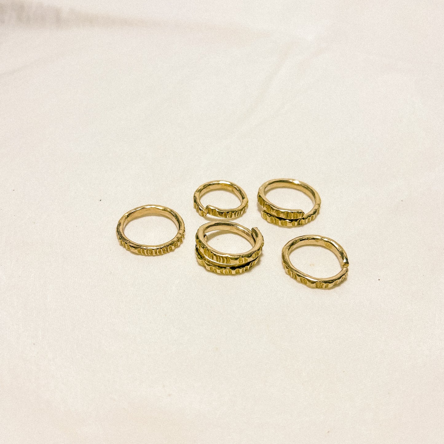 Set of gold rings on a beige background
