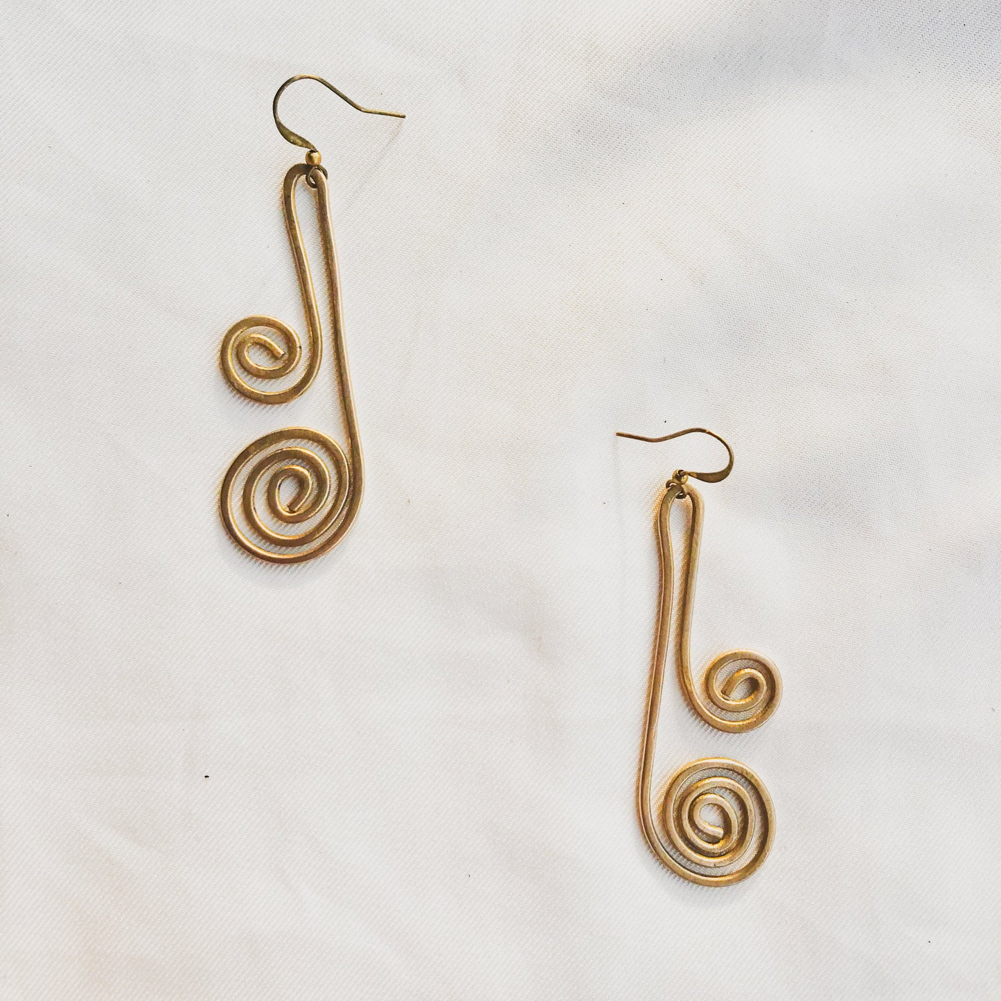 Pair of gold spiral earrings on a white background