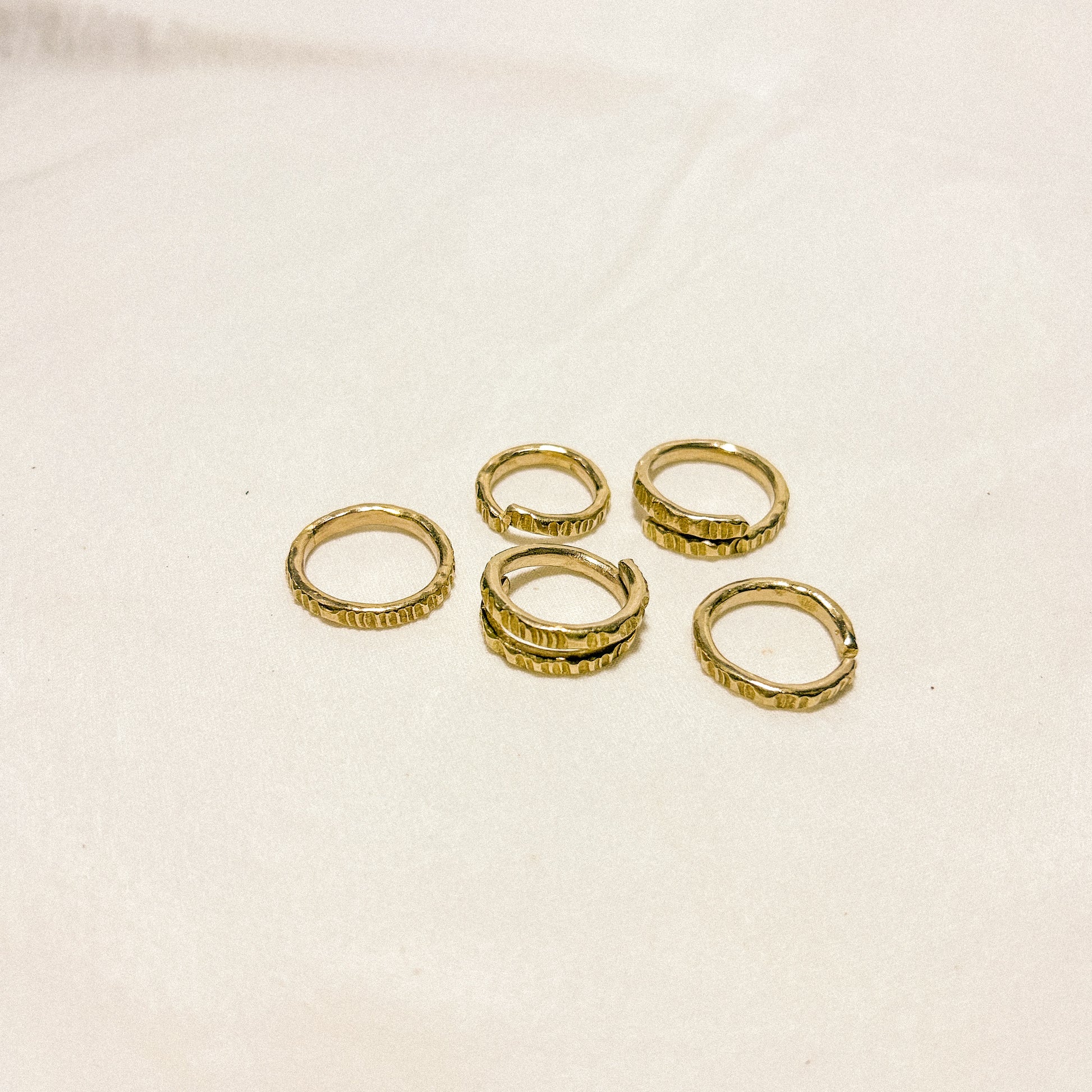 Set of gold rings on a beige background