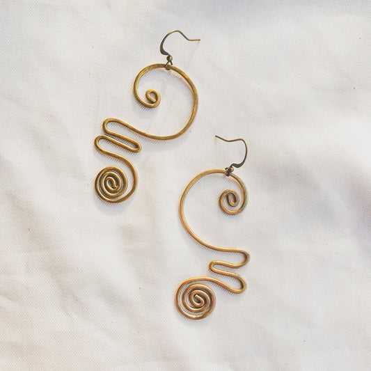 Pair of gold spiral earrings on a light background